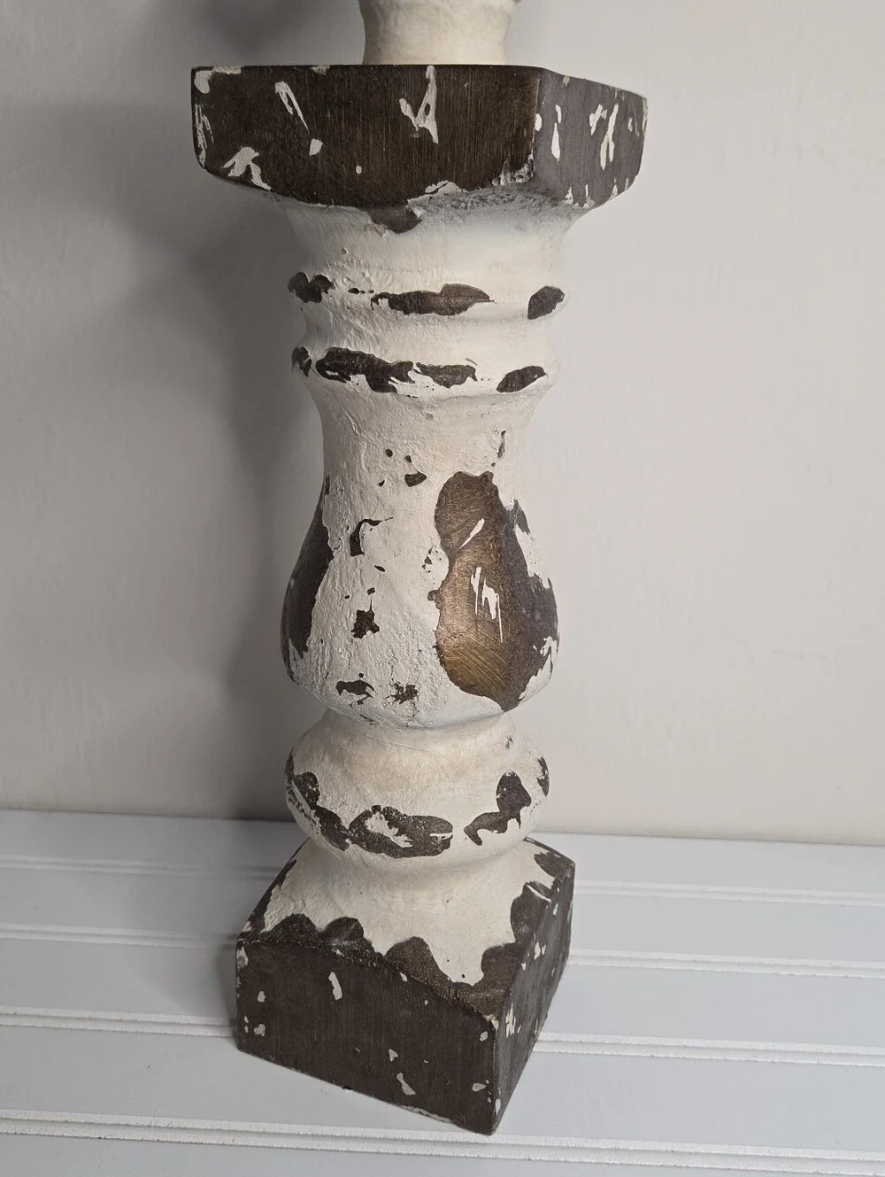 white and gold candlestick features a distressed finish and a lotus-shaped top